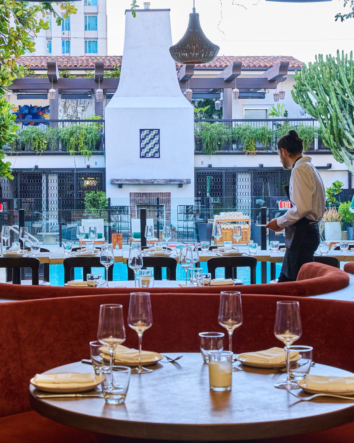 A table set in the Florence by the Water dining room, open to the Hotel Figueroa pool