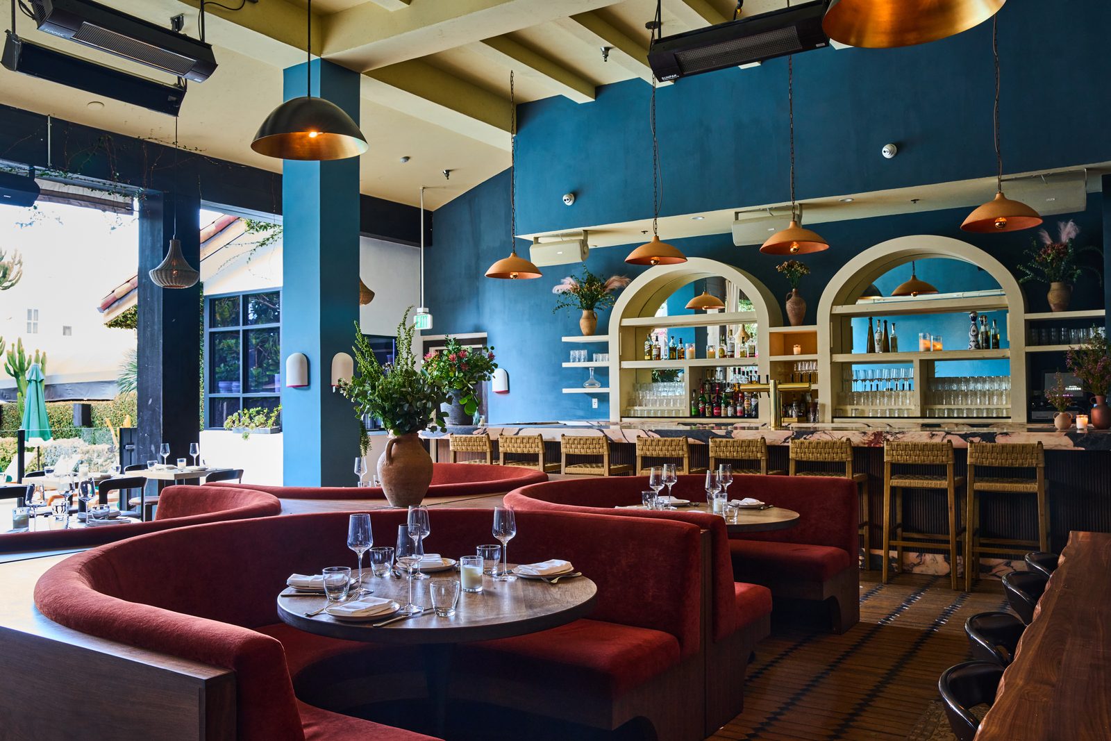 The dining room at Florence by the Water with arched windows and warm pendant lighting